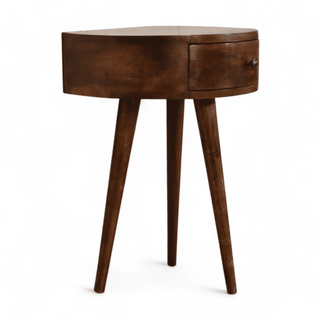 Angled view of the round wood side table, highlighting its curved design and functional single drawer.