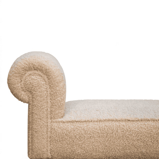 Side view of the beige upholstered bench emphasizing the rolled armrest and smooth fabric finish.