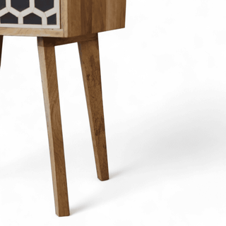 Close-up of tapered wooden leg on mid-century mango wood nightstand, showcasing sturdy craftsmanship and smooth natural finish