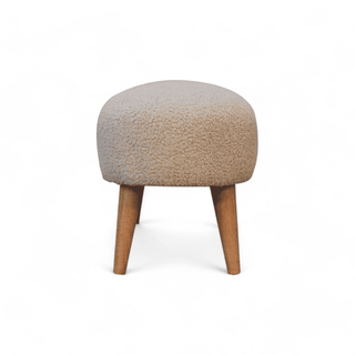 Full side view of the boucle cream bench, showcasing the balance between its legs and upholstery.