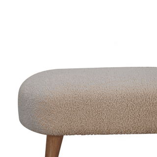 Close-up of the boucle fabric texture on the cream bench, emphasizing its soft and luxurious feel.
