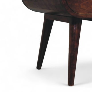 Close-up view of the tapered Nordic-style legs of the oval wooden nightstand, showcasing its sturdy and elegant design.