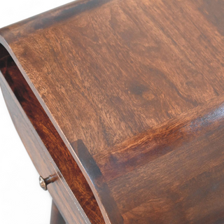 Close-up view of the top surface of the oval wooden nightstand, highlighting its smooth finish and natural wood grain texture.