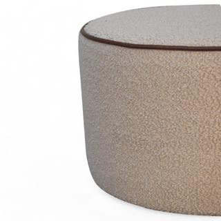 Side view of the Cream Bouclé Ottoman highlighting the even cylindrical shape and clean design.