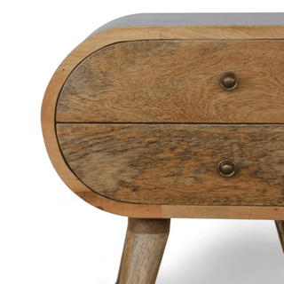 Close-up of the curved edge and wood grain of a mango wood bedside table, highlighting the natural texture and craftsmanship.