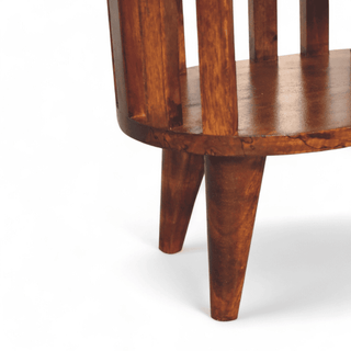 Close-up of the sturdy tapered legs on mid-century solid wood oval nightstand, finished in dark walnut tone