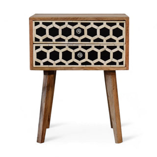 Front view of a decorative wooden nightstand with two drawers featuring a black and white geometric pattern and angled wooden legs.