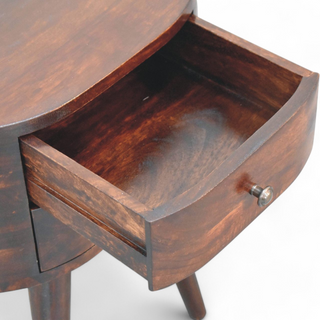 Open drawer of the round walnut nightstand revealing its spacious interior with a smooth finish.