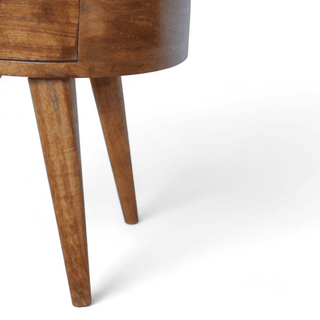 Close-up of tapered wooden legs on mid-century round nightstand, emphasizing stability, craftsmanship, and minimalist design