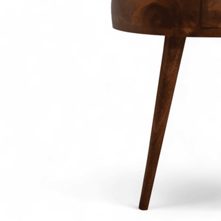 Detailed look at the tapered legs of the round side table, showcasing the sturdy mid-century modern design in chestnut finish.